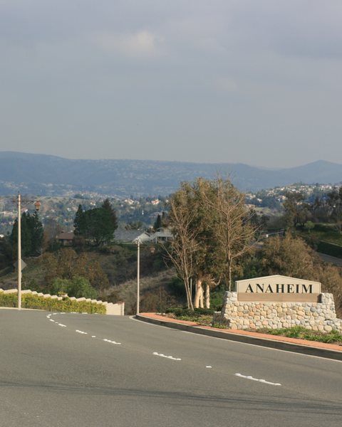 A road and an Anaheim Hills sign with the hills behind