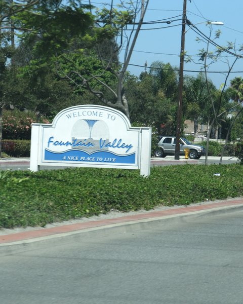A Welcome to Fountain Valley sign beside a street
